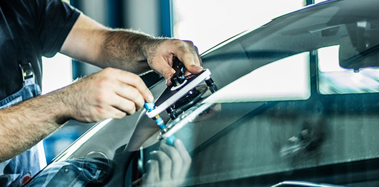 Mechaniker tauscht die Windschutzscheibe eines Autos